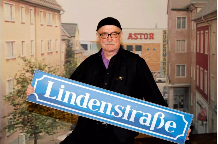 Der Regisseur Hans. W. Geissendoerfer posiert 2010 in Köln bei einem Fototermin anlässlich des 25-jährigen Jubiläums der ARD/WDR Fernsehserie «Lindenstrasse» mit einem Strassenschild.