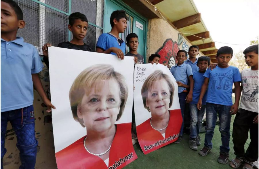 Vor Merkels Besuch in Israel – 02.10.2018, Palästinensische Autonomiegebiete, Chan Al-Ahmar: Palästinensische Kinder halten Poster mit einem Porträt der deutschen Bundeskanzlerin Angela Merkel, auf denen #savekhanalahmar (#rettekhanalahmar) steht. Bundeskanzlerin Merkel reist am 03. Oktober 2018 zu den deutsch-israelischen Regierungskonsultationen in Jerusalem. Mit ihren Plakaten wollen die Kinder aus dem Beduinendorf Chan Al-Ahmar die Kanzlerin darum bitten, sich  bei den Gesprächen in Israel gegen einen Abriss ihres Dorfes einzusetzen. (Bildwiederholung mit Textergänzung) Foto: Wisam Hashlamoun/APA Images via ZUMA Wire/dpa +++ dpa-Bildfunk +++