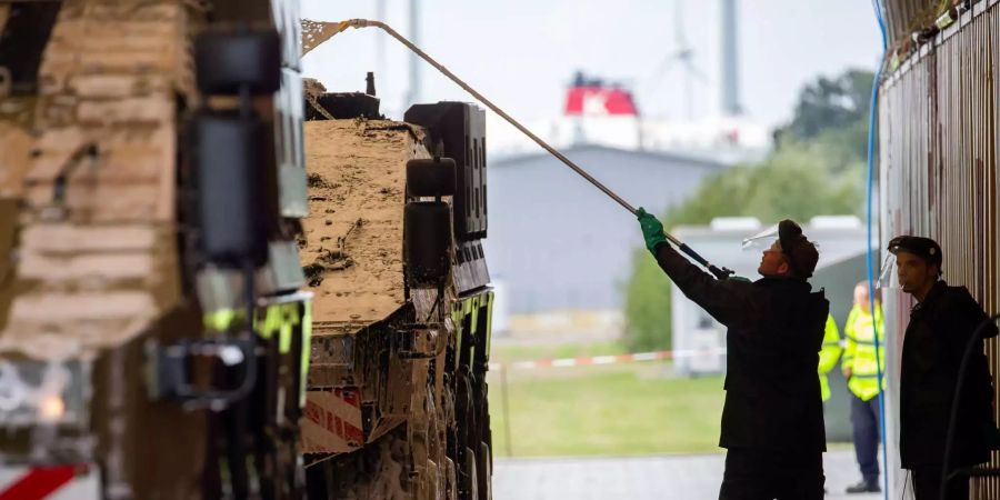 Mitarbeiter der Bundeswehr reinigen auf dem Gelände des Emder Hafens ein gepanzertes Transport-Kraftfahrzeug der Bundeswehr, das im Anschluss auf ein Schiff verladen werden soll.