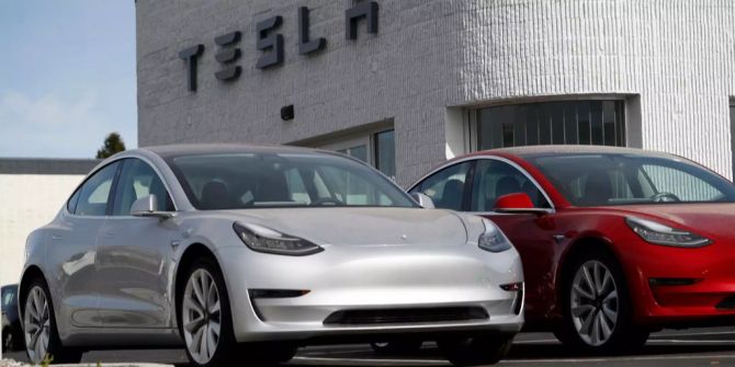 Tesla Model 3 vor einem Tesla-Geschäft.