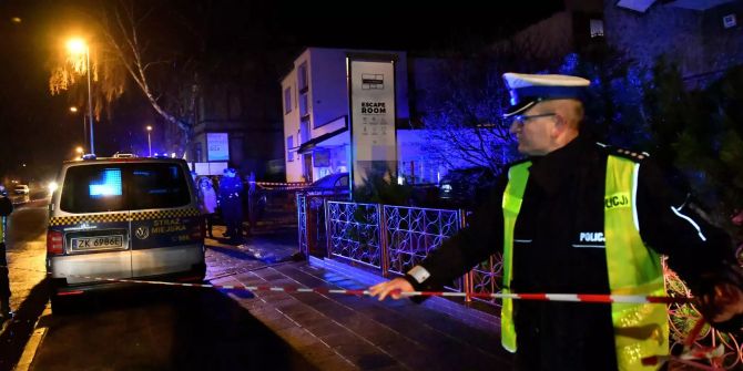 Ein Polizist sperrt den Brandort ab.