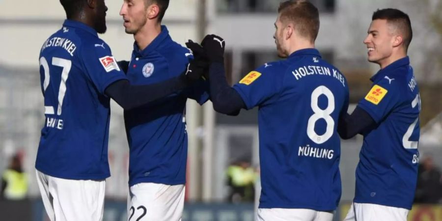 Kiels Kingsley Schindler (l-r), jubelt mit Karazor, Mühling und Benes über seinen Treffer zum 1:0. Foto: Daniel Bockwoldt