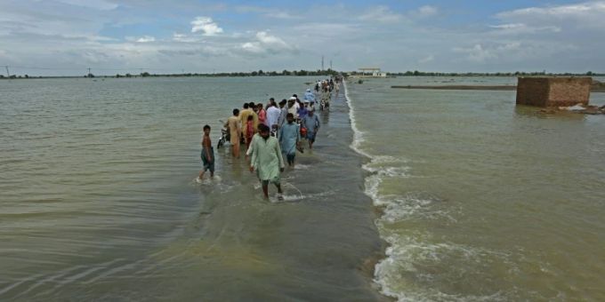 Zeitweise ein Drittel von Pakistan unter Wasser gesetzt. People walk along a flooded road to escape their villages in Punjab province