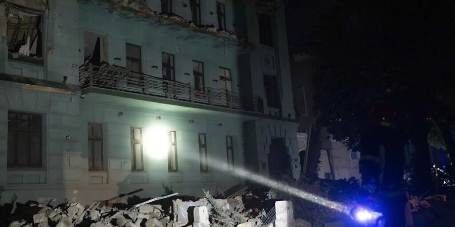 Ein Nothelfer begutachtet mit einer Taschenlampe die Schäden an einem Wohnhaus nach russischen Raketenangriffen in Odessa. Foto: Jae C. Hong/AP/dpa