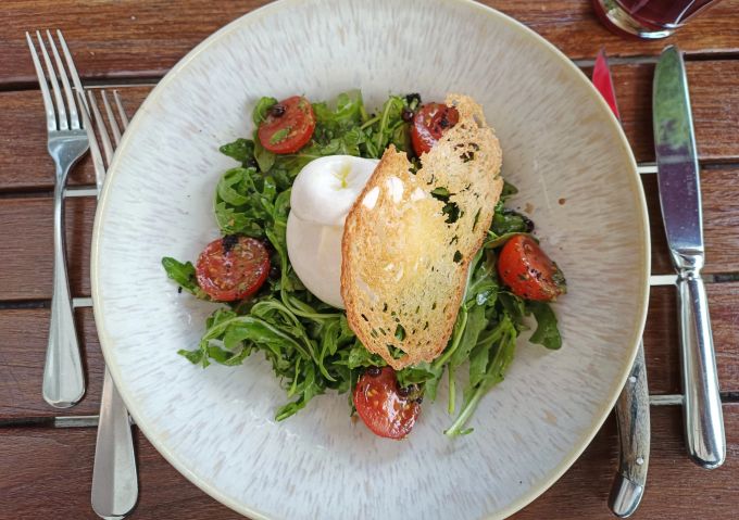 Burrata DOC mit Rucola, Tomaten, Brotchip und Thai Basilikum in der Brasserie Freilager. Brasserie Freilager