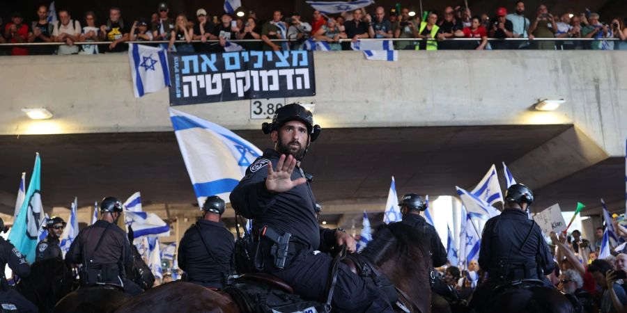 Während einer Kundgebung gegen die geplante Justizreform der israelischen Regierung blockieren Polizisten am Flughafen Ben Gurion Demonstranten.