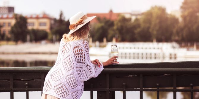 Frau mit Weinglas auf Brücke in Prag