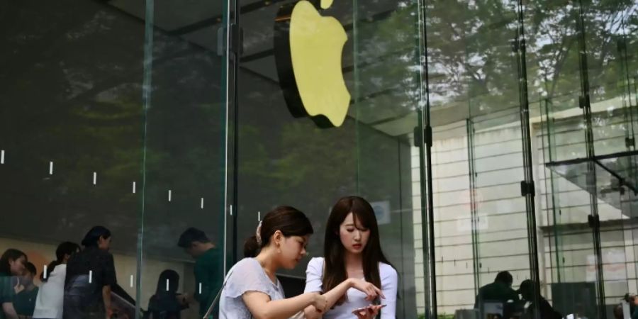 Frauen benutzen Handys vor Apple-Store
