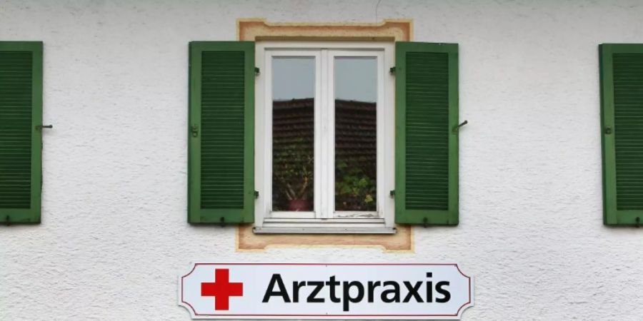 Ein Schild weist auf eine Praxis hin