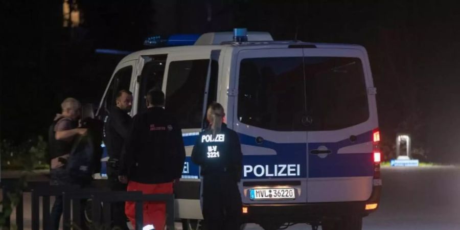 Polizisten bringen den Mann aus Ghana in ein Polizeifahrzeug, den ein Spezialeinsatzkommando in Wismar überwältigt hatte. Foto: Jens Büttner