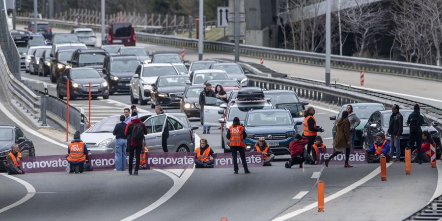 Klimaaktivisten von der Gruppe «Renovate Switzerland» haben sich auf der Fahrbahn vor dem Nordportal des Gotthardstrassentunnels festgeklebt.