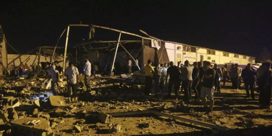 Hilfskräfte untersuchen das Migrantenlager nach dem Angriff. Foto: Hazem Ahmed/AP