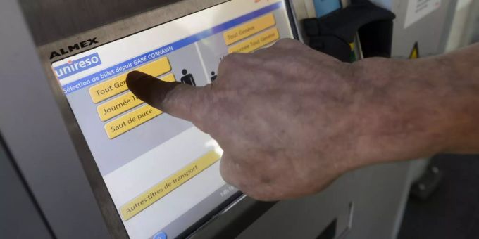 Eine Person löst an einem TPG-Ticketautomaten ein Billet. Ticketautomat