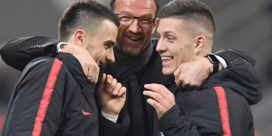 Frankfurts Sportvorstand Fredi Bobic (M) umarmt den nach Madrid wechselnden Luka Jovic (r) und Filip Kostic. Foto: Arne Dedert