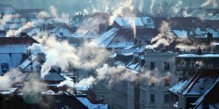 Qualmende Schornsteine von Wohnhäusern in Leipzig im Februar