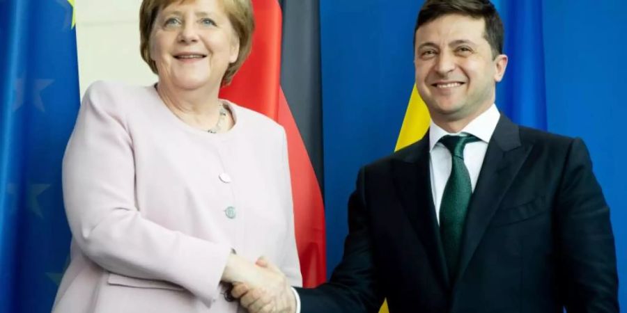 Bundeskanzlerin Angela Merkel und der ukrainische Präsident Wolodymyr Selenskyj reichen sich nach einer Pressekonferenz die Hände. Foto: Kay Nietfeld