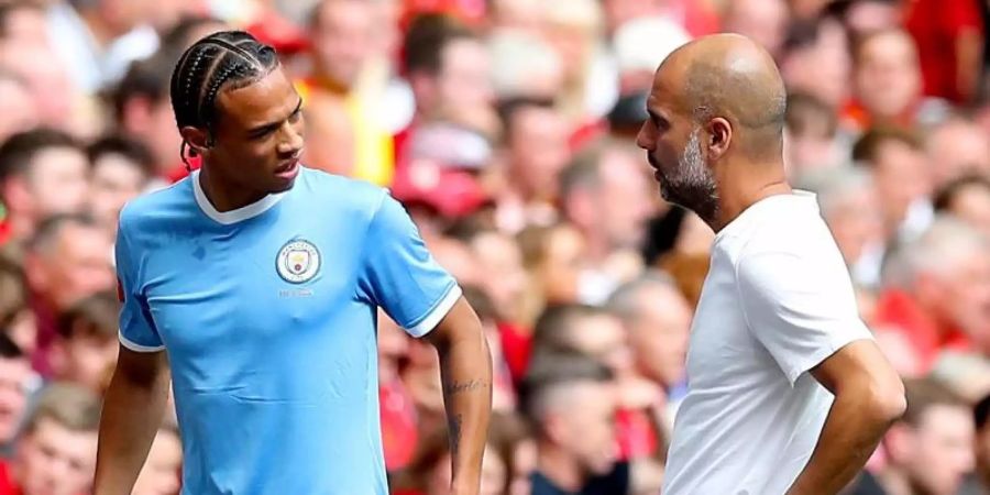 Manchester Citys Leroy Sané (l) spricht nach seiner Auswechslung mit Trainer Pep Guardiola. Foto: Martin Rickett/PA Wire