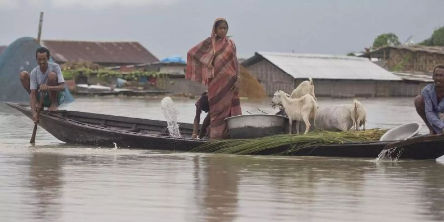 Dorfbewohner fahren mit einem Boot entlang des Flusses Brahmaputra. Heftiger Monsunregen und Gewitter haben in Südasien zahlreiche Überschwemmungen ausgelöst. Foto: Anupam Nath/AP