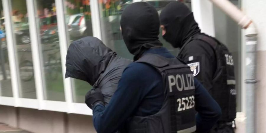 Polizeibeamte führen im Juli in Berlin einen Mann ab. Foto: Paul Zinken