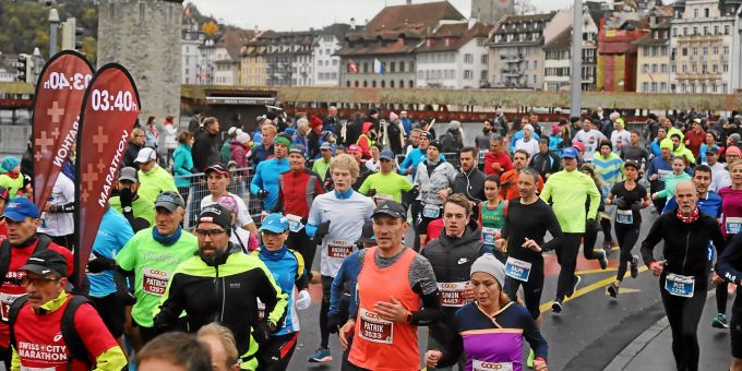 Teilnehmende des Swiss City Marathon 2018 laufen über die Kappelbrücke in Luzern. Marathonlauf