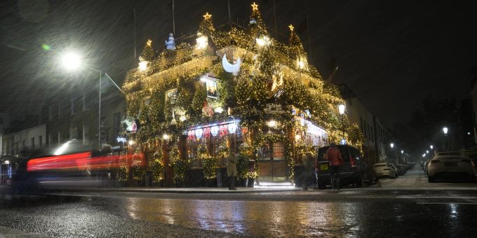 Schnee fällt vor dem bekannten Churchill Arms Pub im Westen Londons, Sonntag, 11. Dezember 2022. Schnee Pub Grossbritannien