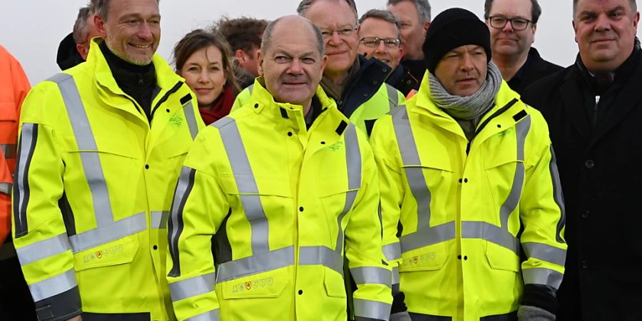 In Wilhelmshaven ist am Samstag im Beisein von Finanzminister Christian Lindner, Kanzler Olaf Scholz und Wirtschaftsminister Robert Habeck (von links nach rechts in Schutzwesten) der erste deutschen Importterminal für Flüssigerdgas (LNG) eröffnet worden.