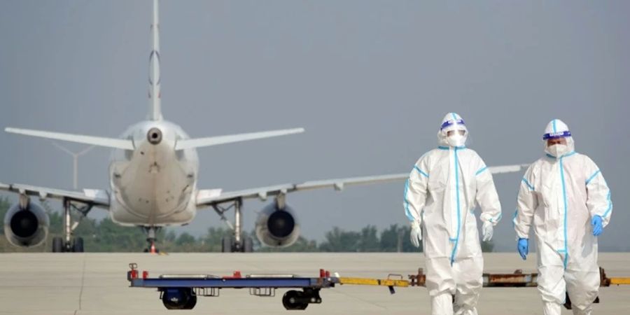 Personal in Schutzanzügen auf chinesischem Airport