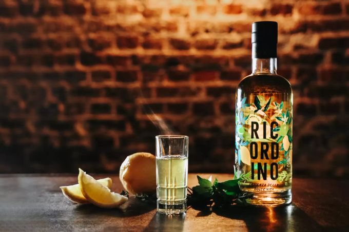 Für vier «Hot Lemon»-Shots werden 120 ml Ricordino, ein Aperitif aus Kräutern und Zitrusfrüchten, 80 ml Zitronensaft unter Rühren erhitzt, ohne zu kochen. Flasche Ricordino Zitronenschnitze Glas Shot