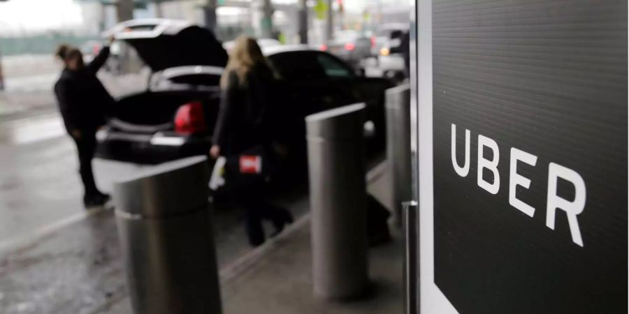 Ein Schild mit dem Logo des amerikanischen Dienstleistungsunternehmens Uber am Abholpunkt von Uber auf dem LaGuardia-Flughafen in New York (USA).