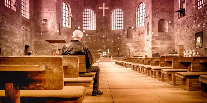 Ein Mann sitzt in einer katholischen Kirche. (Symbolbild) Diözese