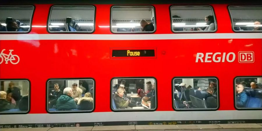 Bahnreisende sitzen in einem Regionalzug am Hauptbahnhof.