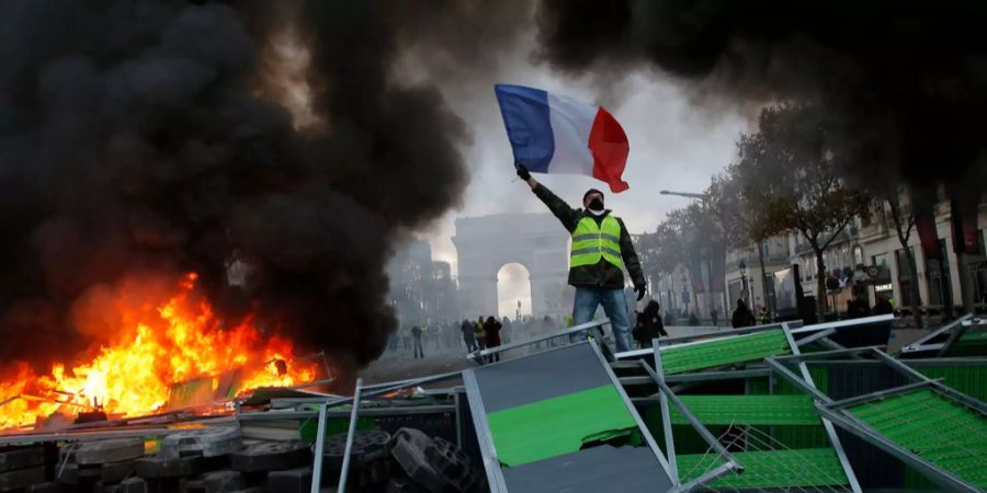 Gelbwesten Demonstrieren mit einer Frankreich-Flagge in Prais - Kommt es auch am fünften Wochenende zu Ausschreitungen?