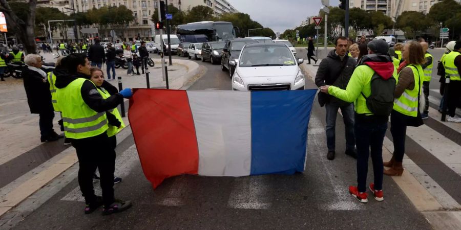 Demonstranten stehen in Marseille und protestieren mit gelben Westen gegen den Spritpreis.