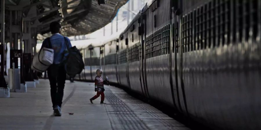 Ein Zug und ein Bahnsteig in Indien.