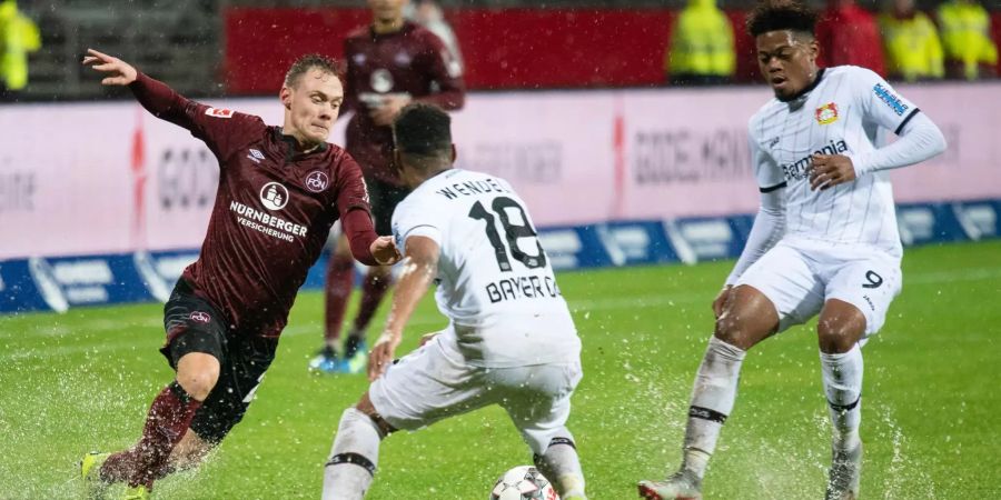 Nürnbergs Federico Palacios (l) kämpft mit Leverkusens Wendell (M) und Leon Bailey (r) um den Ball.