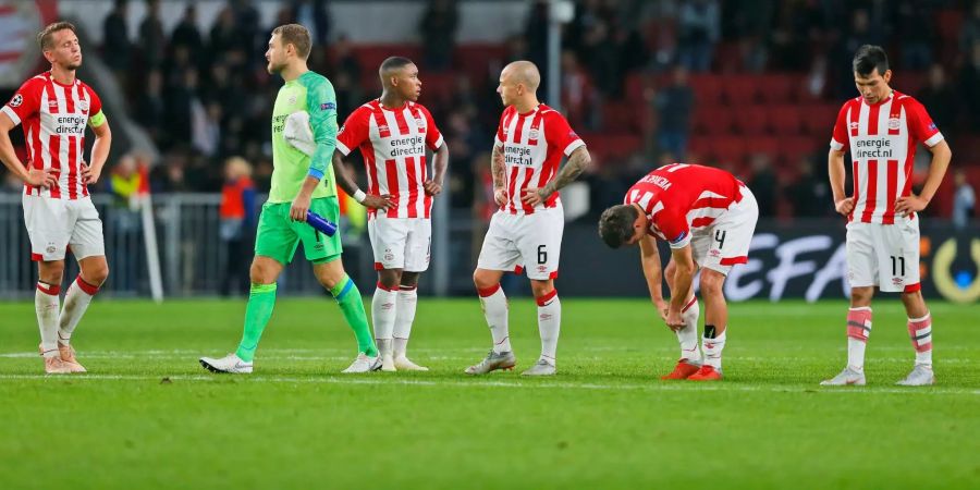 Enttäuschte PSV-Spieler stehen nach einem Spiel auf dem Platz.