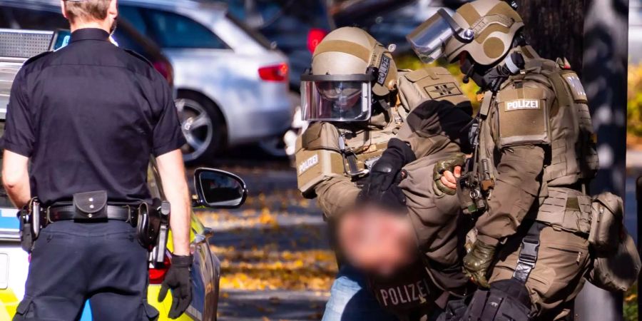 Mitglieder einer Spezialeinheit der Polizei führen einer Mann aus einer Wohnung im Stadtteil Wandsbek ab.