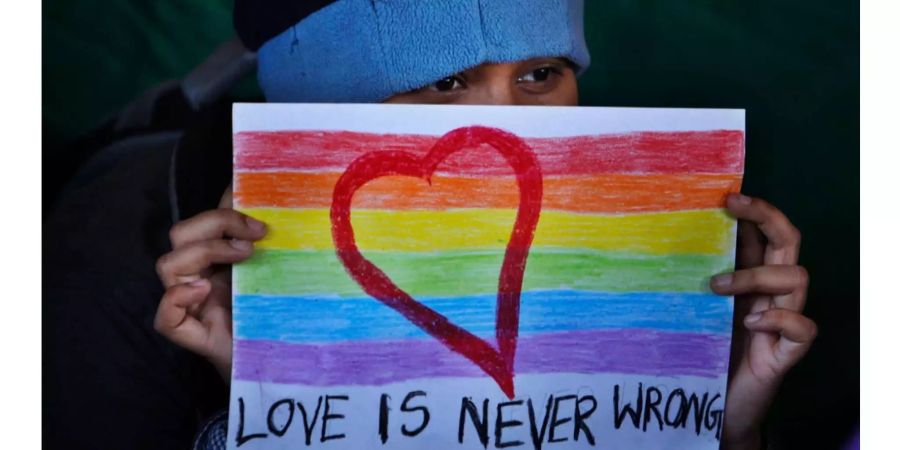 Ein indischer LGBT-Aktivist hebt bei einer Demonstration ein Plakat mit dem Spruch «Love is never wrong» (Deutsch: «Liebe ist nie falsch») in die Luft.