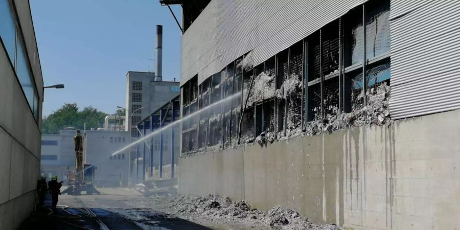 Feuerwehrleute löschen den Brand bei der Papierfabrik in Utzenstorf BE.