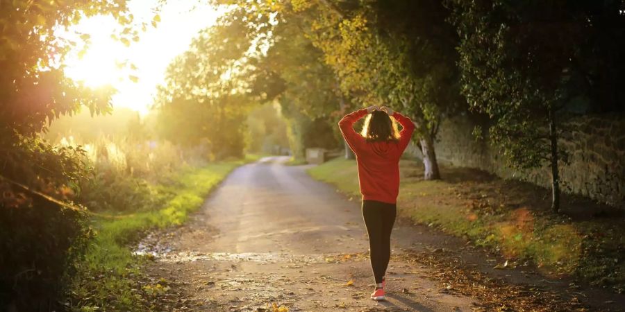 Eine Sportlerin am Morgen auf einem Weg.