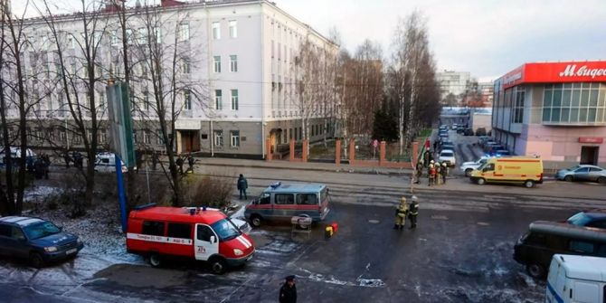 Feuerwehrleute und Polizisten stehen beim Geheimdienstbüro in Archangelsk.