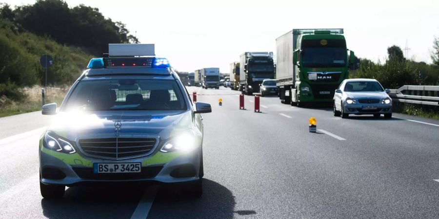 Ein Streifenwagen der Polizei steht auf der Autobahn. (Symbolbild)