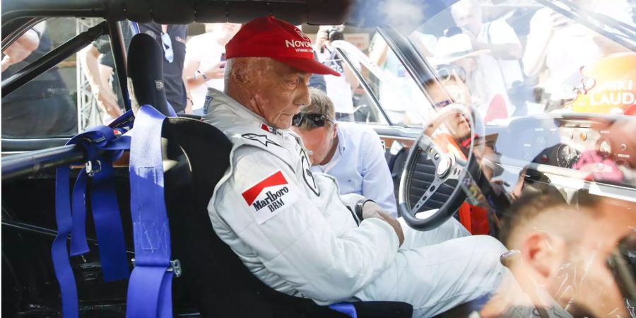 Formel-1-Legende Niki Lauda sitzt während des Legenden-Rennens am Red Bull Ring in Spielberg (AUT) am Lenkrad.