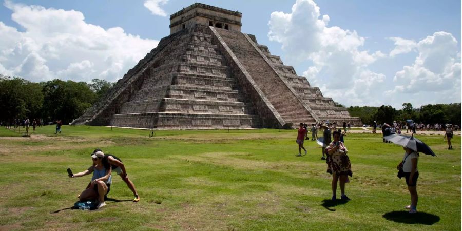 Touristen betrachten die ehemalige Pyramide der Mayas auf der mexikanischen Halbinsel Yucatán.