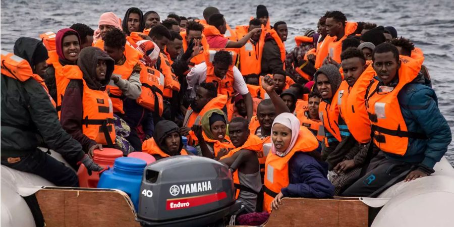 Flüchtlinge mit Schwimmwesten auf einem Boot.