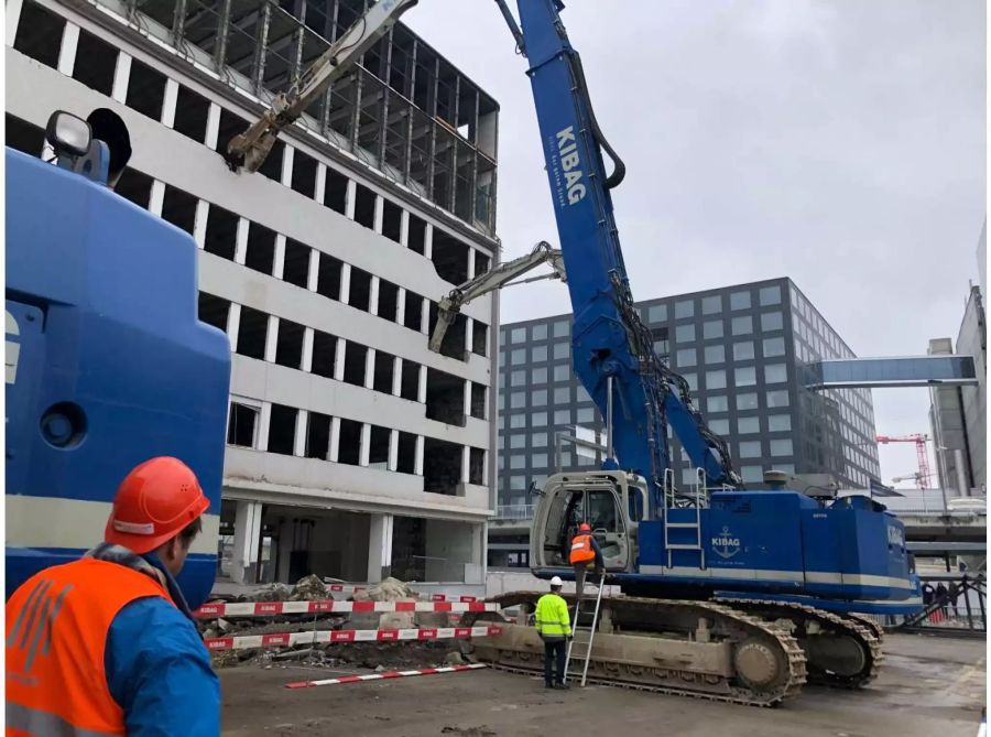 Einer der grössten Bagger in der Schweiz reisst seit heute das alte Flughafengebäude ab.