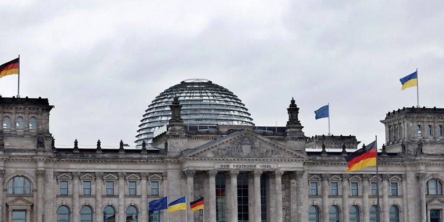 Auf dem Reichstagsgebäude ist neben der schwarz-rot-goldene Bundesflagge und Europaflagge die ukrainische Flagge zum Zeichen der Solidarität mit dem ukrainischen Volk gehisst. Foto: Carsten Koall/dpa