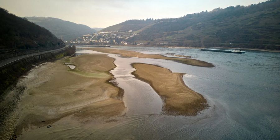 Schiffe passieren bei einem für die Jahreszeit ungewöhnlich niedrigen Wasserstand die Sandbank am Jungfrauengrund am Mittelrhein.