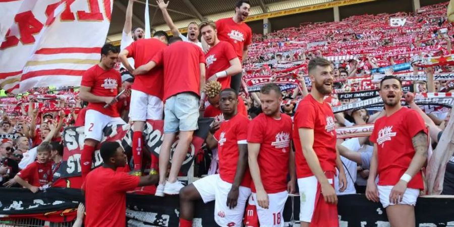 Ausgelassen: Mainz-Coach Sandro Schwarz (Mitte hinten) feiert nach dem Sieg gegen Düsseldorf zusammen mit seinen Spielern und den Fans. Foto: