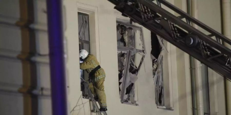 Ein Feuerwehrmann steigt durch ein Fenster in ein Gebäude der St. Petersburger Universität. Foto: Dmitri Lovetsky/AP